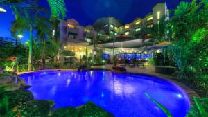 una piscina frente a un hotel por la noche en Cairns Sheridan Hotel, en Cairns
