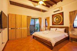a bedroom with a bed and a television in it at Tropical Family Retreat near Ya Nui Beach - Villa Nikkie in Nai Harn Beach +11 photos