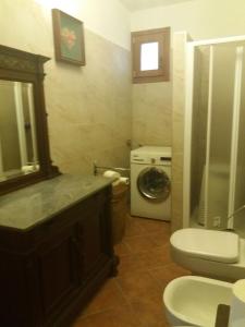 uma casa de banho com um lavatório e uma máquina de lavar roupa em cimmo em Tavernole sul Mella