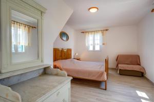 a bedroom with a bed and a chair at Apartments Valun in Valun