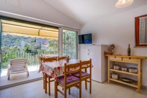 a kitchen with a table and chairs and a refrigerator at Apartments Valun in Valun