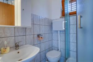 a bathroom with a toilet and a sink and a shower at Apartments Valun in Valun +94 photos