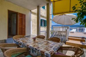 a table with chairs and an umbrella on a patio at Apartments Valun in Valun