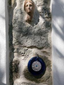 a statue of a head and a blue frisbee at Arcadia Guesthouse in Eresos +44 photos