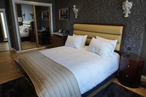 um quarto com uma cama grande e um espelho em Halvard Hotel em Douglas