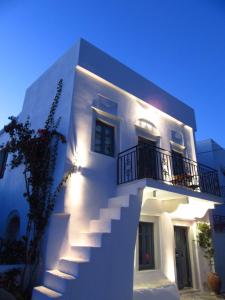 a white building with stairs on the side of it at Magnificent traditional house in the centre of Naxos in Khalkíon