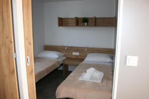 a small room with two beds and a mirror at Mobile Homes Katinka, Starigrad Paklenica, Croatia in Starigrad-Paklenica