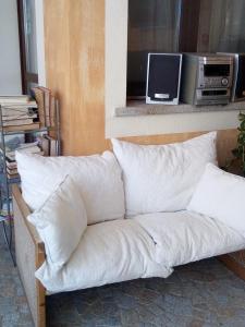 un divano con cuscini bianchi, posto in una stanza di Hotel Sa Cralla a Villasimius