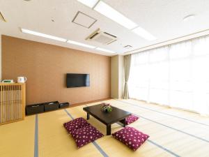 a room with two chairs and a table and a tv at Hotel Abest Naha Kokusai Street in Naha