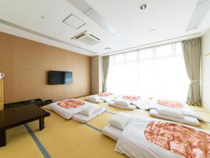 a hotel room with four beds and a television at Hotel Abest Naha Kokusai Street in Naha