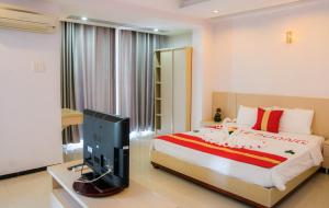 een slaapkamer met een bed en een flatscreen-tv bij Le Duong Hotel in Nha Trang