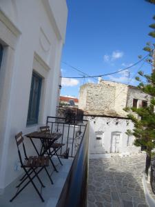 a balcony with chairs and tables on a building at Magnificent traditional house in the centre of Naxos in Khalkíon
