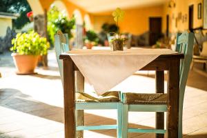 a wooden table and chairs with a table cloth on it at Agriturismo Barbagia in Alghero