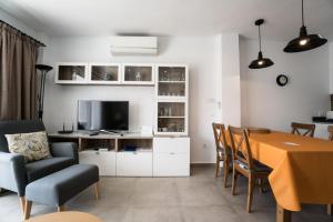 een woonkamer met een eettafel en een televisie bij Torresol 408 Menyber in Nerja