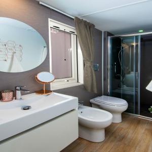 a bathroom with a sink and a toilet and a mirror at Campofelice Camping Village in Tenero