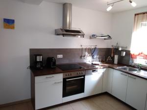 a kitchen with white cabinets and a stove top oven at House of ‘Welcome in Dannstadt-Schauernheim