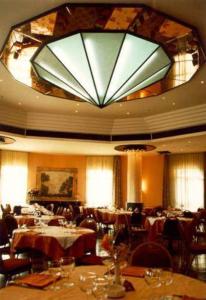 a large dining room with tables and a large chandelier at Hotel Ambasciatori in Calitri