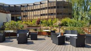 a patio with tables and chairs in front of a building at Ile du Gua Suites in Narbonne +48 photos