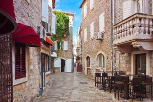 an alley with tables and chairs in an old town at Altstadt von Budva in Budva
