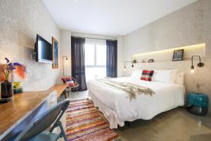 a hotel room with a large bed and a desk at Kook Hotel Tarifa in Tarifa