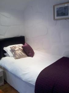 uma cama com duas almofadas num quarto em Finn MacCools Public House & Guest Inn em Bushmills