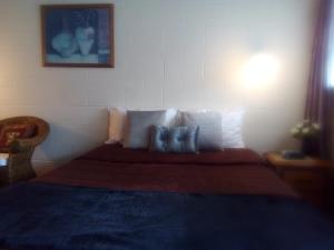 a bedroom with a bed with pillows on it at Redwood Lodge Motel in Levin