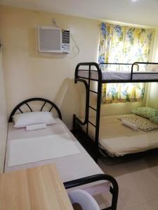 a room with two bunk beds and a fan at Haus Of Tubo Davao in Davao City