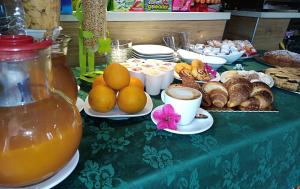 a table with a green table cloth with bread and orange juice at R&B Il Parco in Assergi