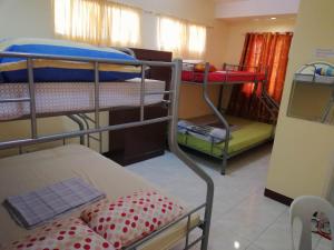 a room with three bunk beds in a room at Haus Of Tubo Davao in Davao City