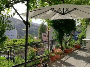 a patio with an umbrella and potted plants at Christos House in Kakopetria