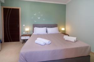 a bedroom with a large bed with two pillows on it at K for Kefalonia in Karavomylos