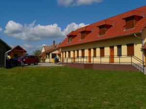 een gebouw met een rood dak en een parkeerplaats bij s'Schnoganeschd in Nemesvid