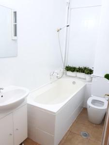 a white bathroom with a tub and a toilet at Studio Old Center in Bucharest +25 photos