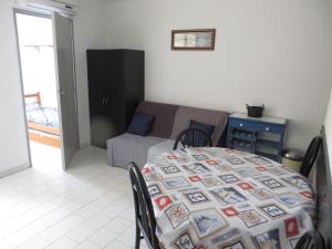 Habitación con mesa, cama, mesa y sillas. en Appartement Carnon Plage, en Carnon-Plage