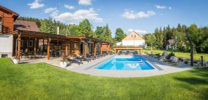 a house with a swimming pool in the yard at Chalet Schäfer in Harrachov