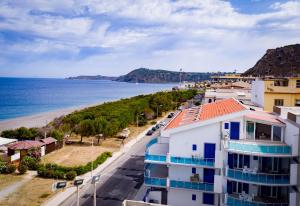 a view of a beach and buildings and the ocean at Le Casette di Ponente in Milazzo