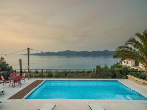 a swimming pool with a view of the water at Villa Iž in Veli Iž