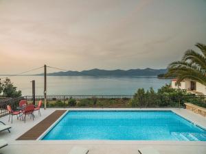 a swimming pool with a view of the water at Villa Iž in Veli Iž