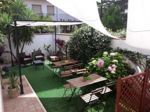 un patio esterno con tavoli, sedie e fiori di Villa Elena a Montesilvano