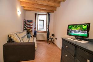 a living room with a tv and a couch at Appartamento Centro Storico Riva in Riva del Garda