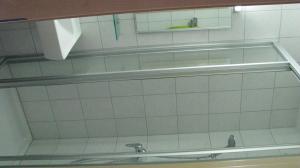 baño con pared de azulejos blancos y lavabo en Haus Schmidl en Zell am See