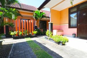 a house with orange walls and palm trees at Sayang Residence I in Denpasar