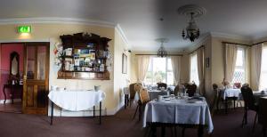 a dining room with two tables with white table cloth at Grove House in Carlingford