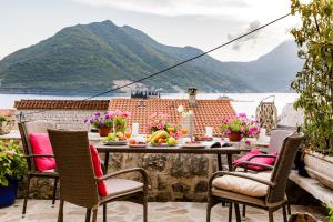 a table and chairs on a patio with a view of the water at Perast Venetian Jewel in Perast