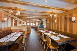 a restaurant with wooden walls and tables and chairs at Hotel du Lac in Villars-sur-Ollon