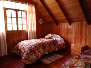 a bedroom with two beds and a window at La Cabaña de Noa in Oxapampa