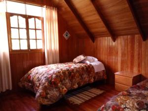 a bedroom with two beds and a window at La Cabaña de Noa in Oxapampa +11 photos