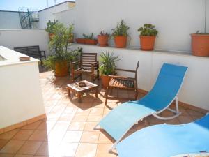 a patio with chairs and tables and potted plants at CASE COLOMBO E MATTARELLA- Appartamenti centrali con wi-fi e parcheggio privato gratuito in San Vito lo Capo