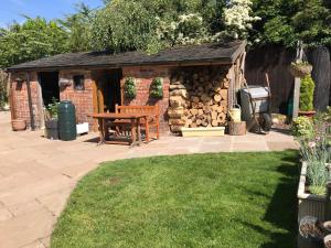 a shed with a wooden table in a yard at Tresillian House in Melton Mowbray
