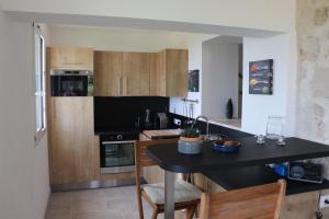 a kitchen with a black counter and wooden cabinets at 205 route de la turbie in Èze
